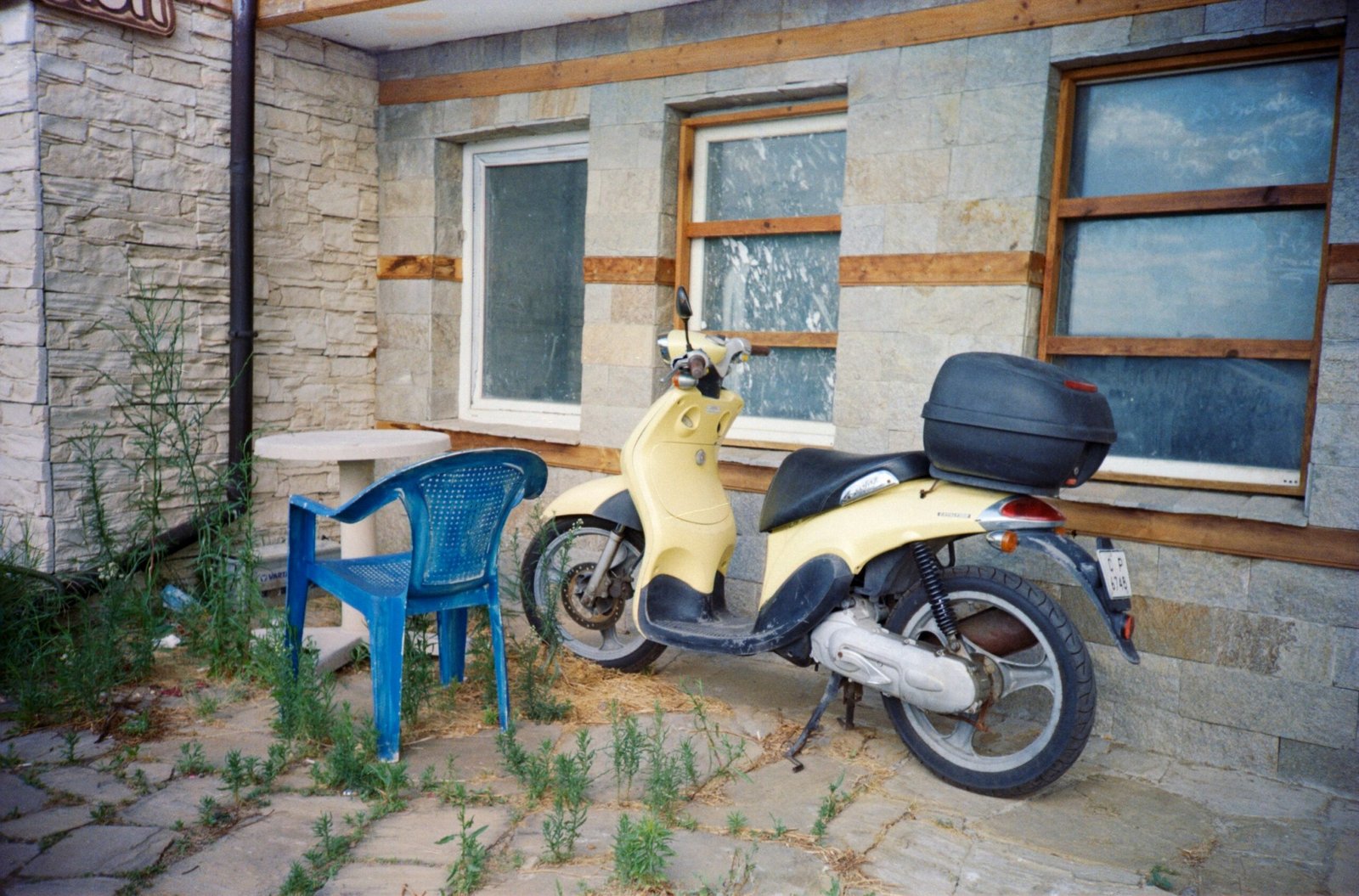 a yellow scooter parked next to a blue chair